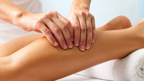 Person massaging their leg with a blurred background